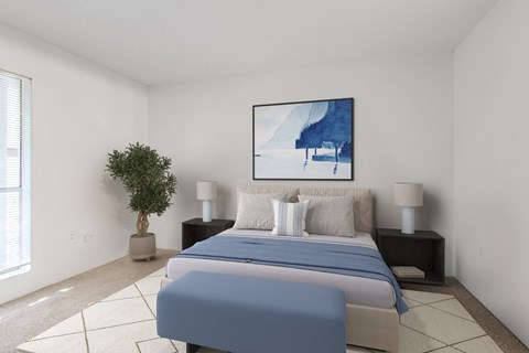 A bedroom with a large bed and a painting on the wall.