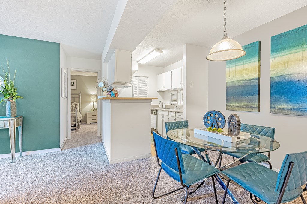 A dining room with a glass table and blue chairs. at Grove at St. Andrews, Columbia