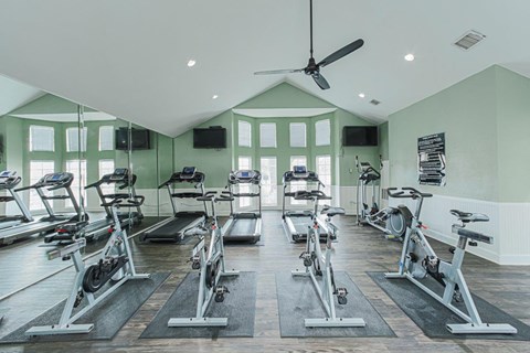 A gym with a row of stationary bikes.