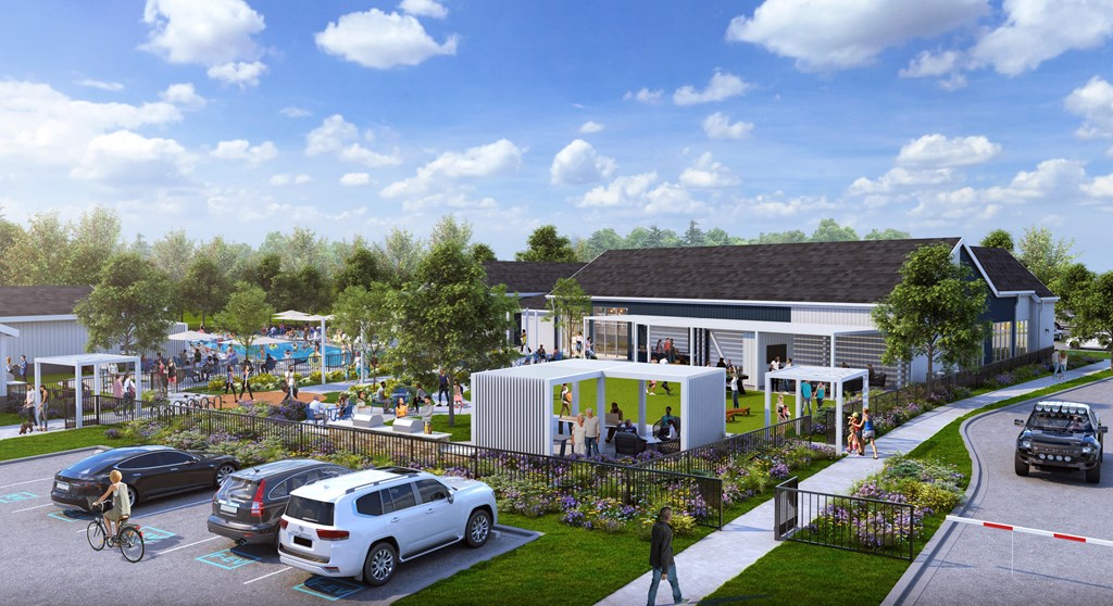 A modern building with a green lawn in front and cars parked nearby.