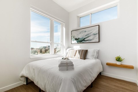 A bedroom with a large bed and a painting on the wall.