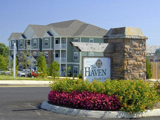 Entrance with flower beds and sign at The Haven at Knob Creek Apartments, - Photo Gallery 1