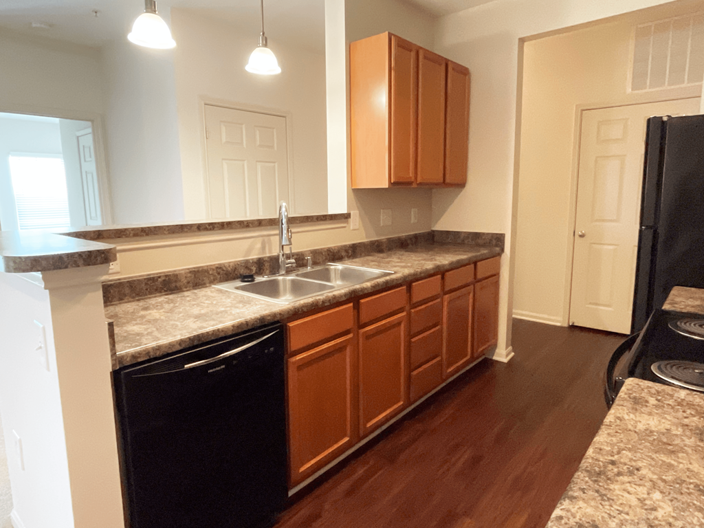 a kitchen with granite counter tops and wooden cabinets