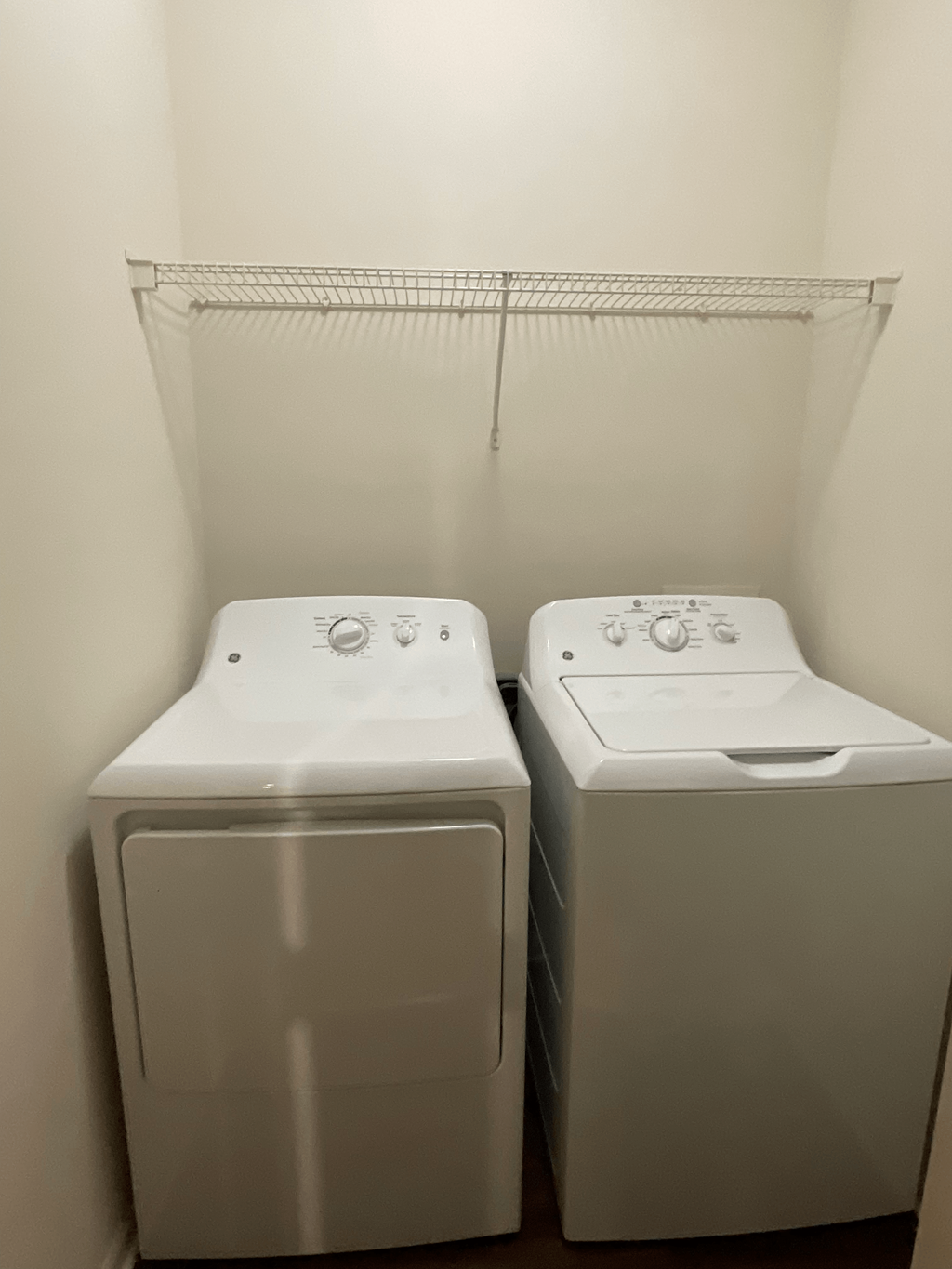 two washers and dryers in a room with a white wall
