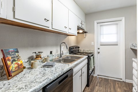 a kitchen with white cabinets and a granite counter top at Summit Augusta, Georgia