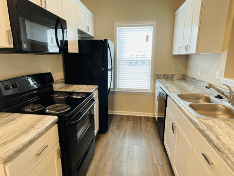 a kitchen with black appliances and white cabinets