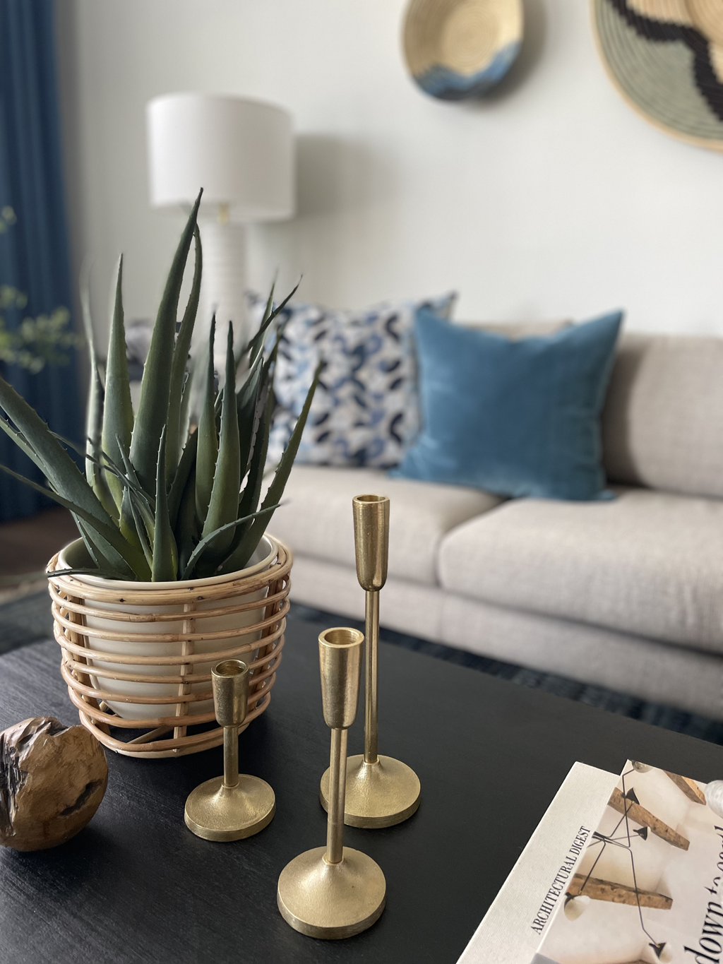 a coffee table with a plant and brass candlesticks on it at The Cannon, Murfreesboro, TN