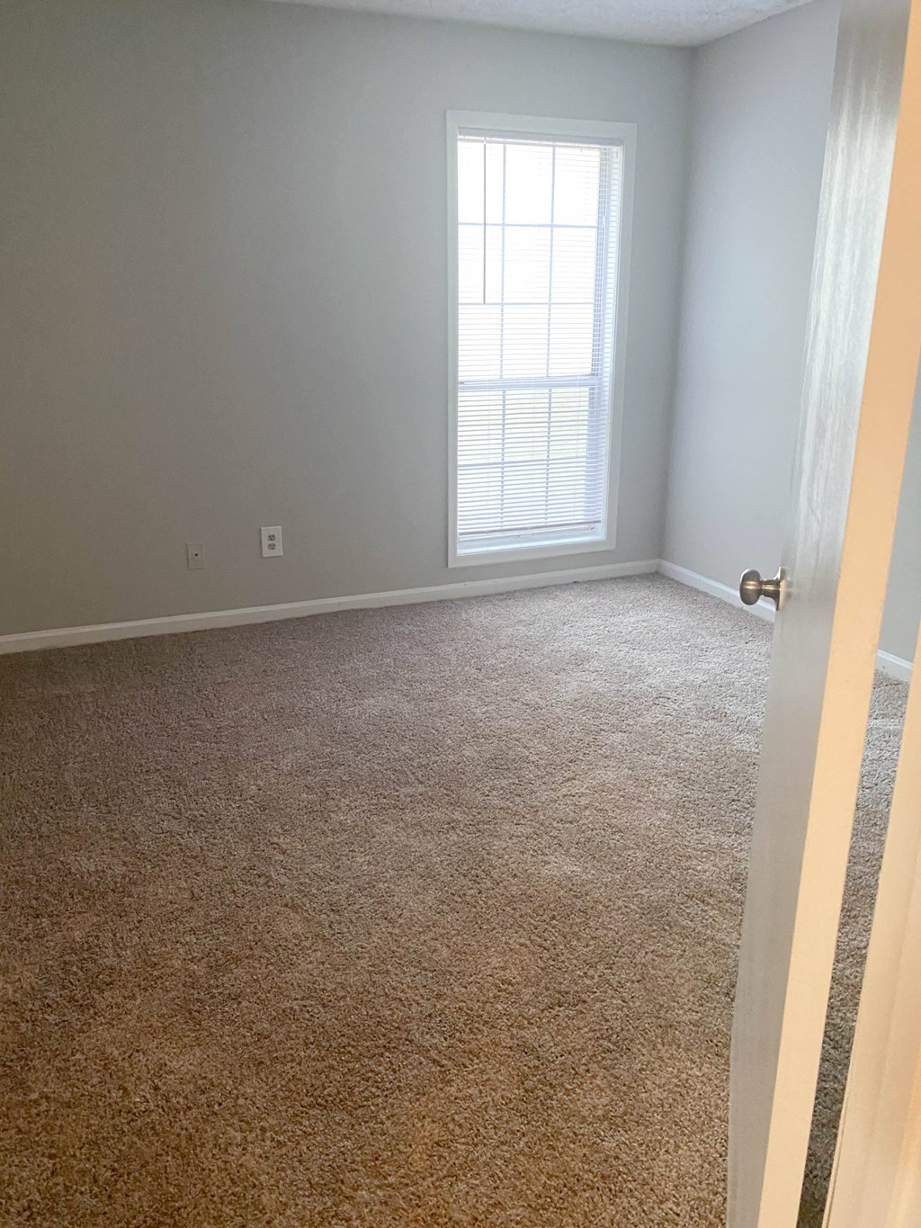 a room with a carpeted floor and a window