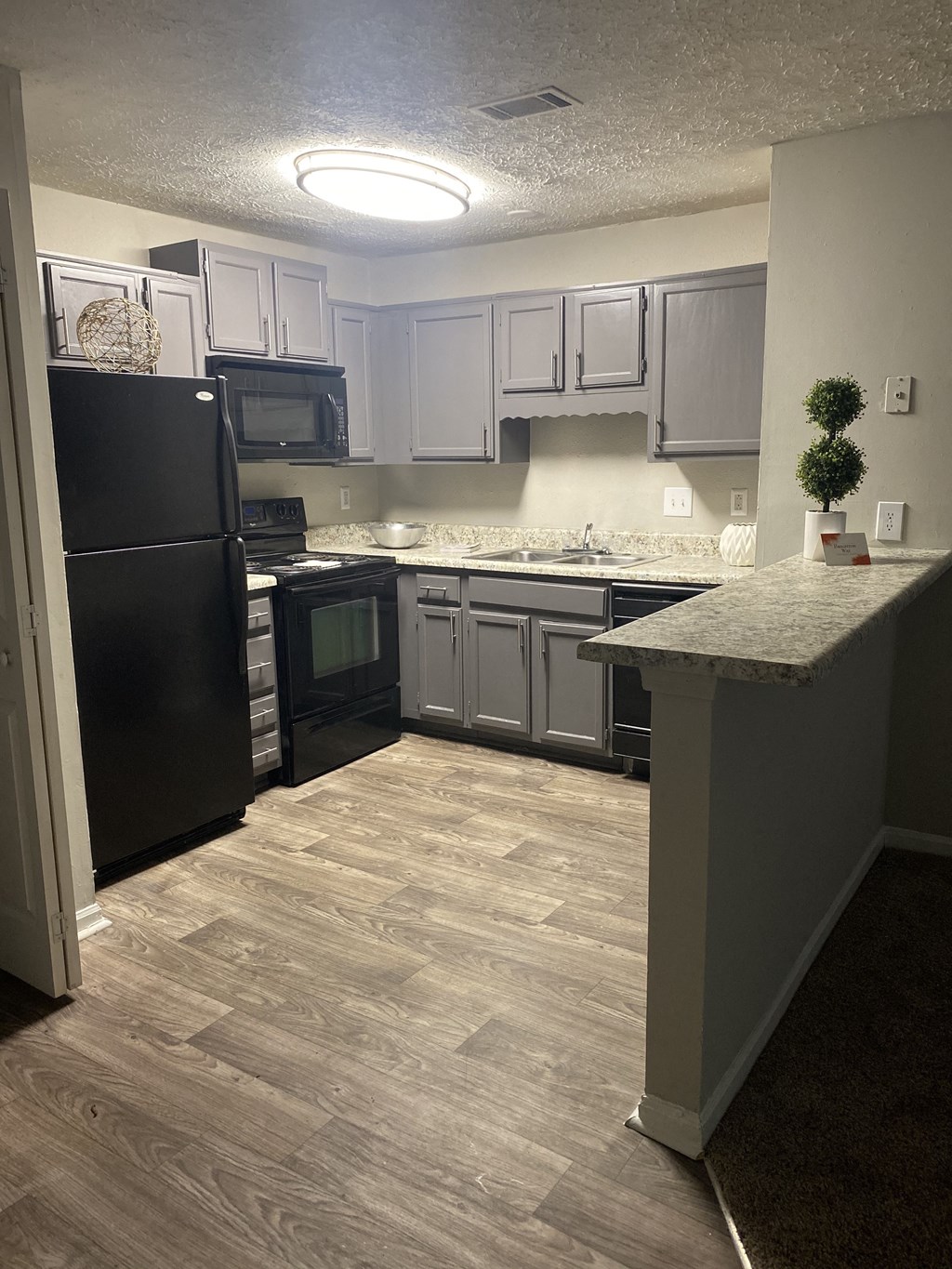 a kitchen with white cabinets and a black refrigerator