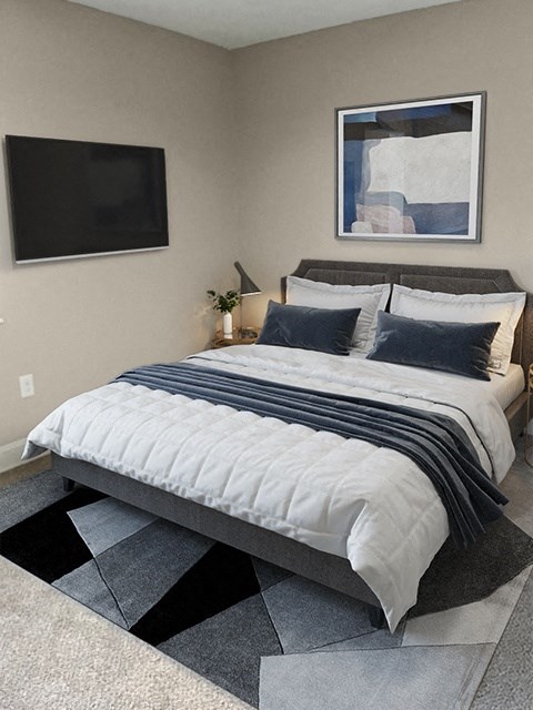 a bedroom with a bed and a television on the wall