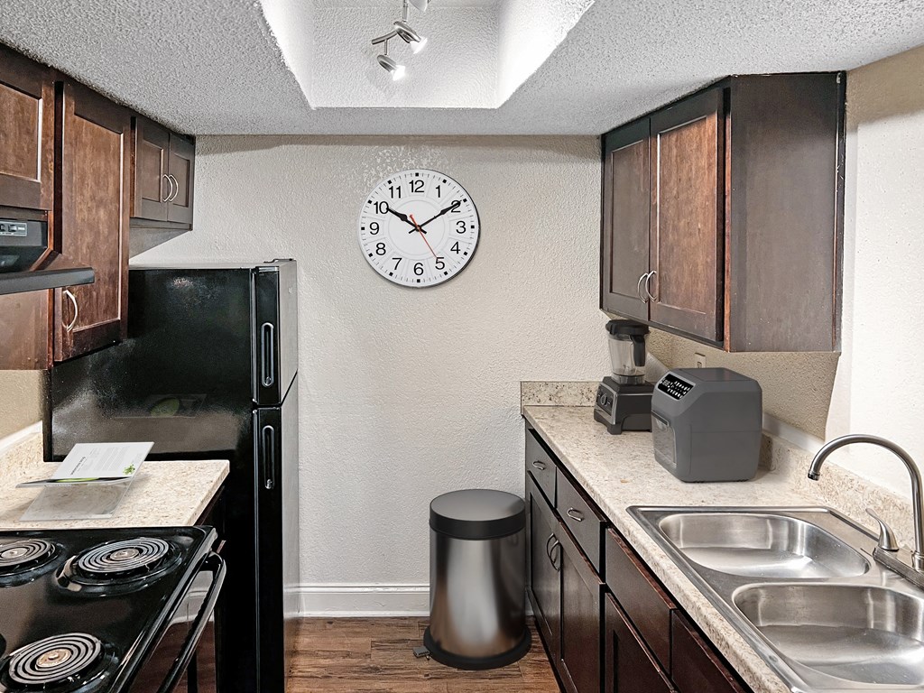 a kitchen with a sink and a clock on the wall