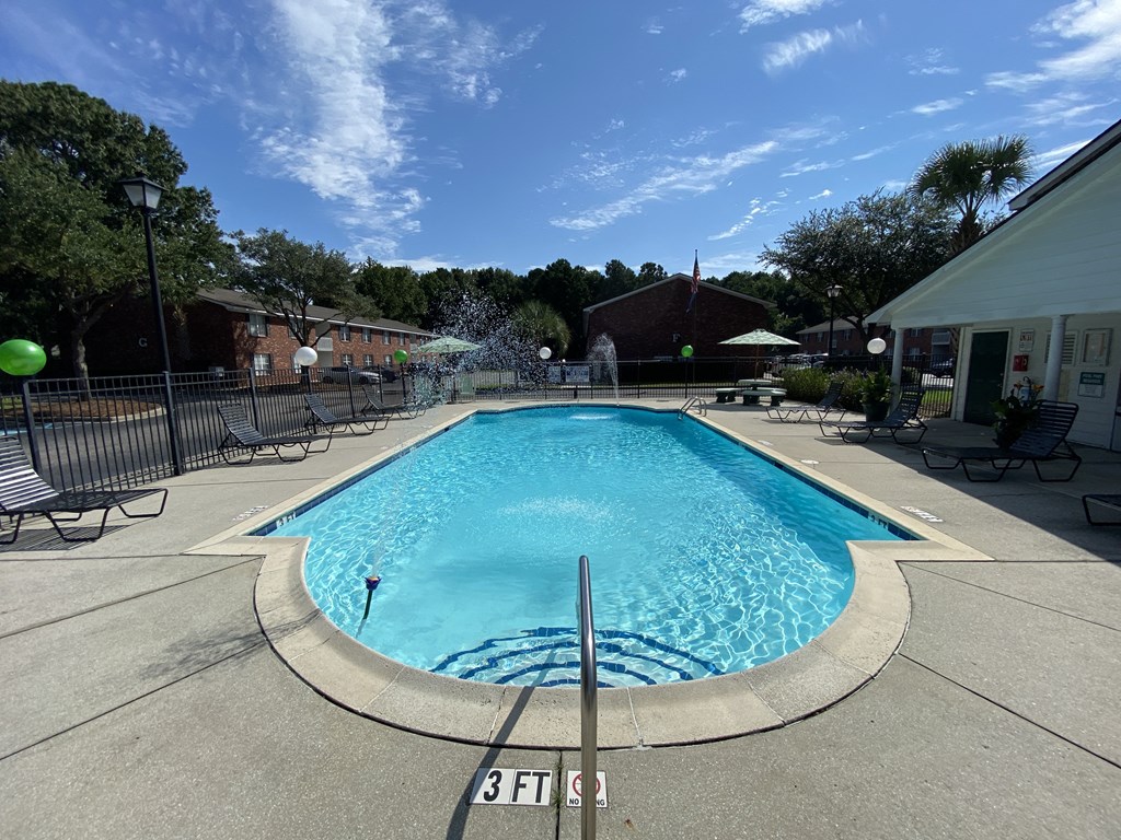 Apartments in North Charleston for Rent - The Retreat at Palm Pointe Apartments Gated Pool Surrounded By Lounging Chairs With Access to Apartments
