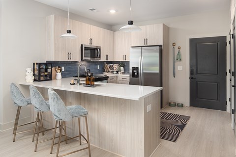 A kitchen with a bar area and a fridge.