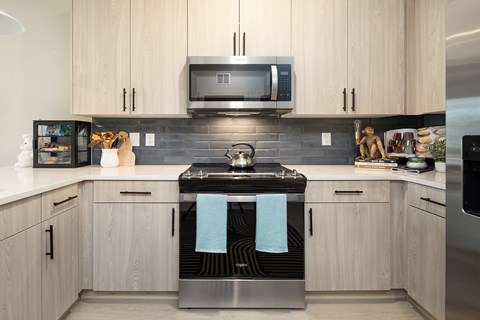 A modern kitchen with wooden cabinets and a stainless steel island.