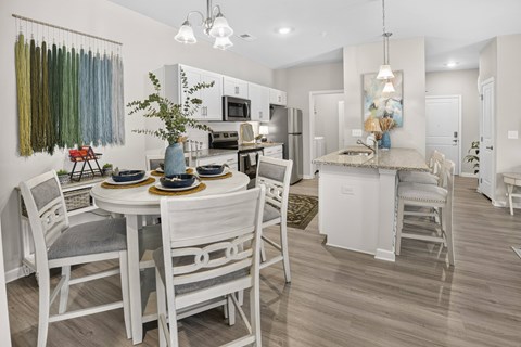 A dining room with a white table and chairs.