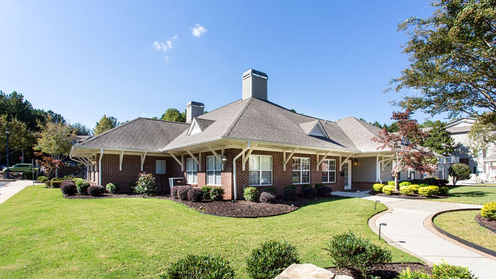 a house with a lawn and a sidew at Indigo Apartments Gainesville, Gainesvillealk in front of it