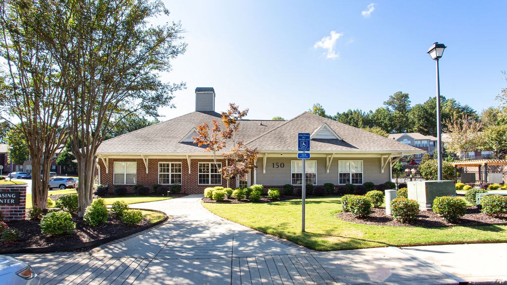 the front of a brick house with a lawn and trees at Indigo Apartments Gainesville, Gainesville, GA