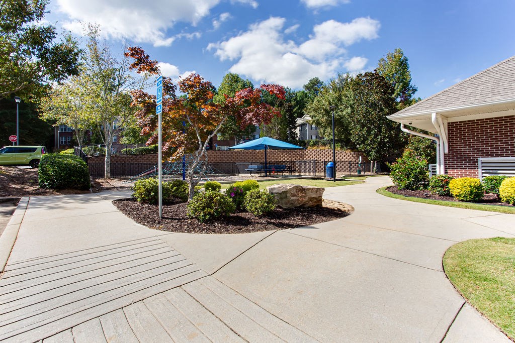a driveway leading to a house with a playground and trees at Indigo Apartments Gainesville, Gainesville, GA 30504
