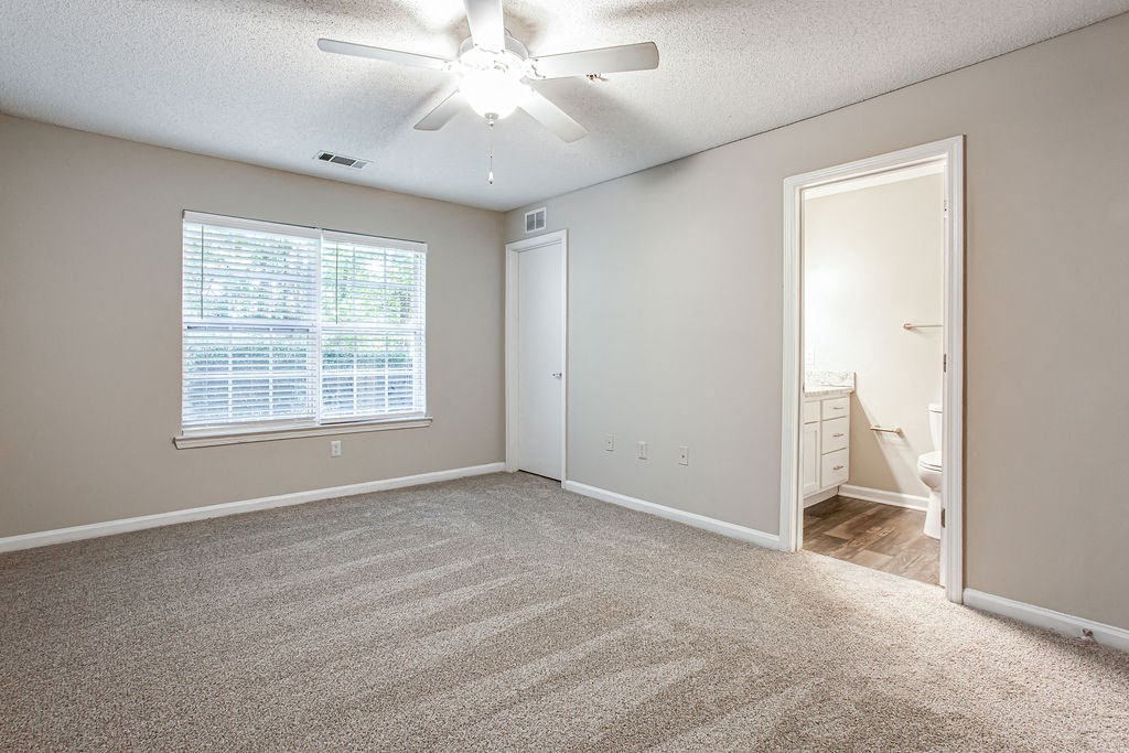 an empty living room with a large window and a ceiling fan at Indigo Apartments Gainesville, Gainesville, GA 30504