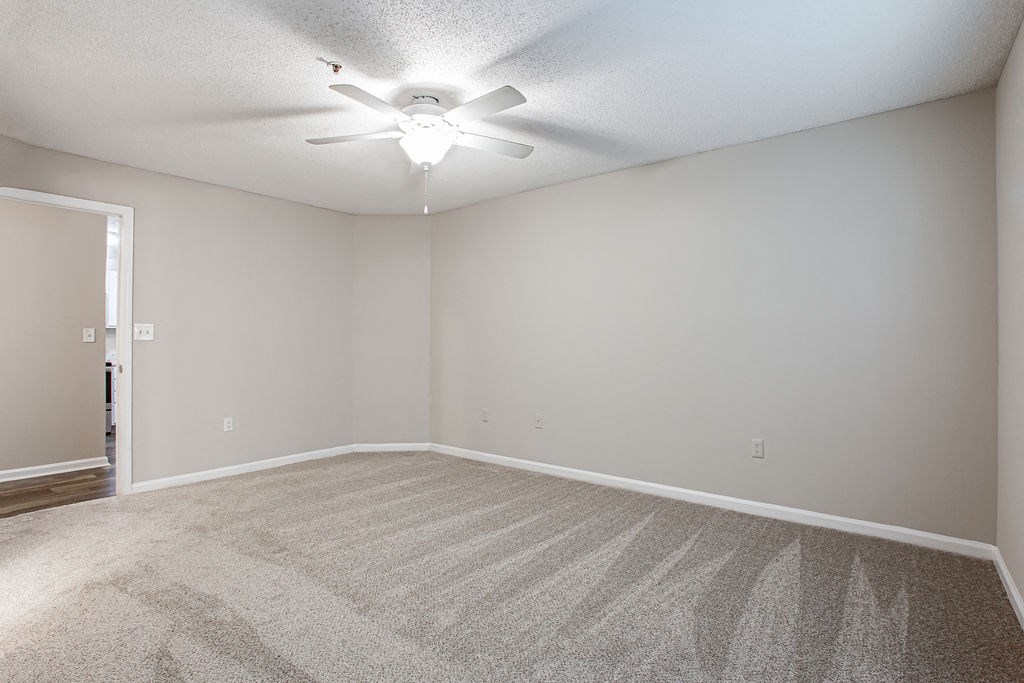 an empty living room with a ceiling fan at Indigo Apartments Gainesville, Gainesville