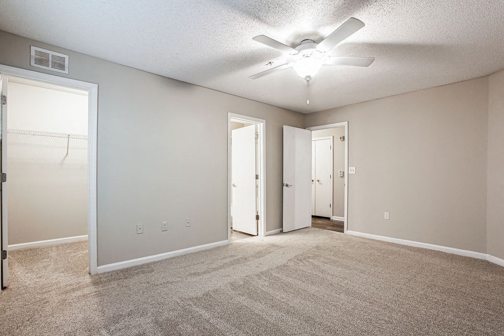 an empty living room with a ceiling fan at Indigo Apartments Gainesville, Gainesville