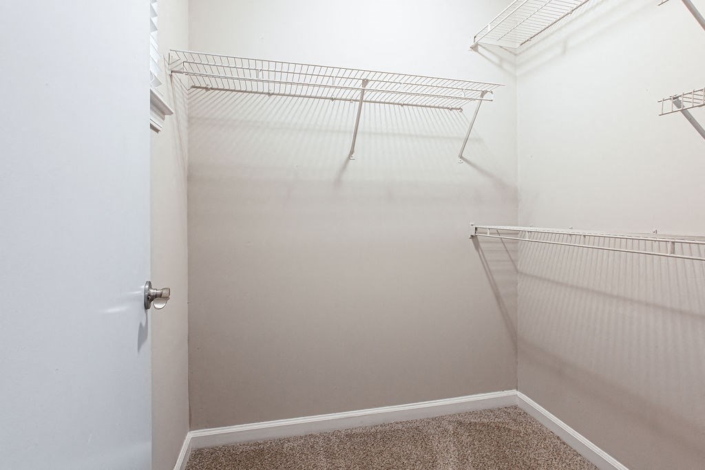 an empty walk in closet in a bathroom with a white door at Indigo Apartments Gainesville, Georgia