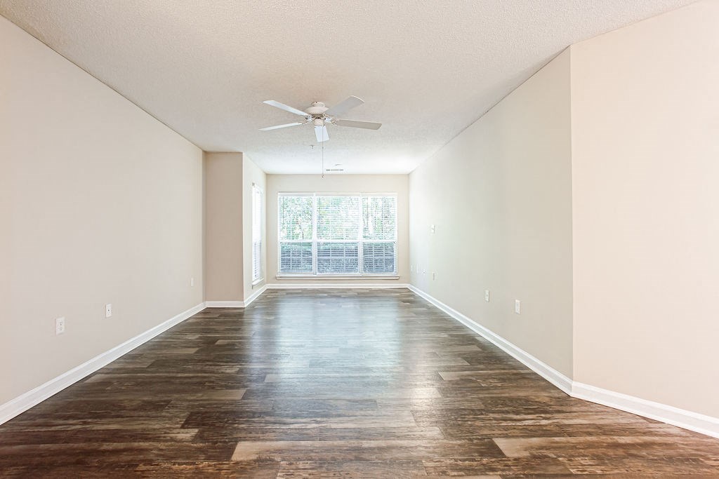 an empty living room with a large window and a ceiling fan at Indigo Apartments Gainesville, Gainesville, GA