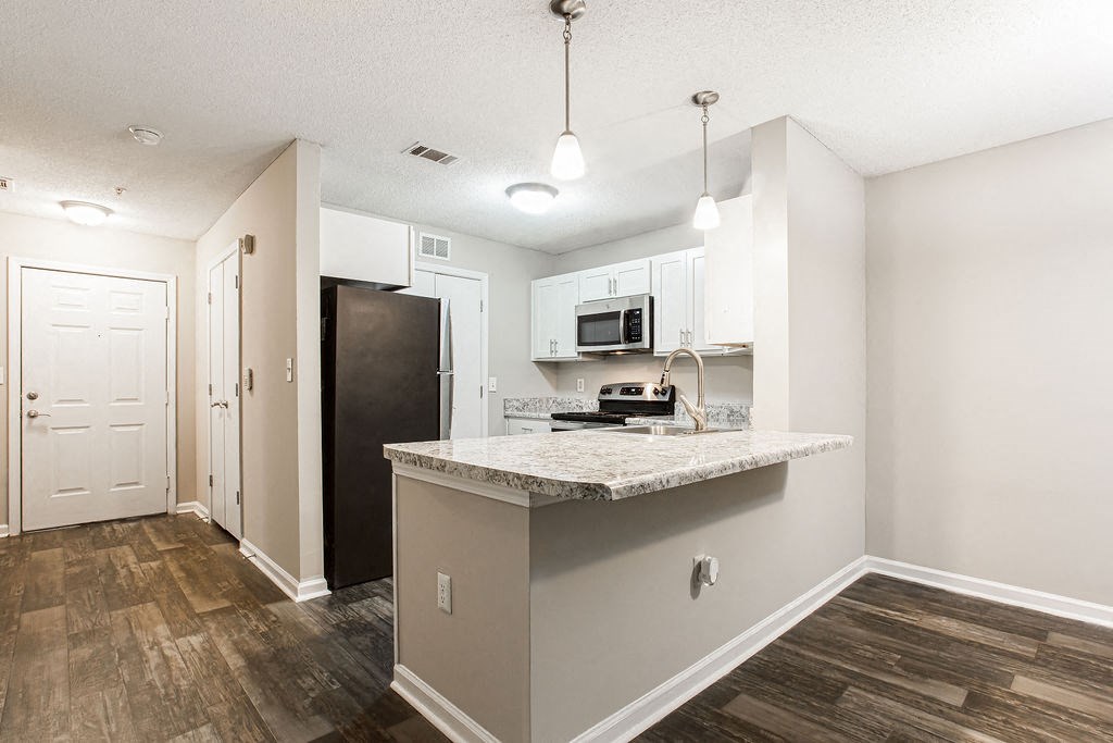 a kitchen with a counter top and a refrigerator at Indigo Apartments Gainesville, Gainesville, GA 30504