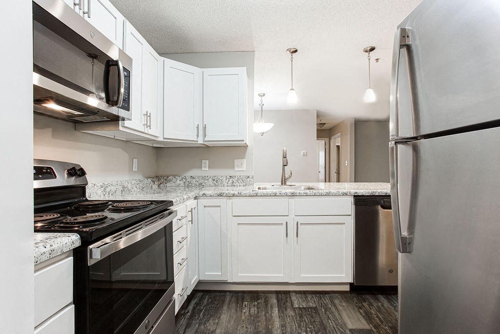 a kitchen with white cabinets and stainless steel appliances at Indigo Apartments Gainesville, Gainesville Georgia