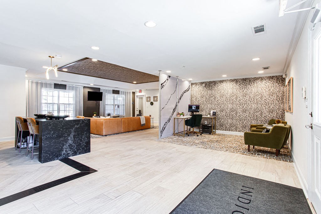 a lobby with a reception desk and a living room at Indigo Apartments Gainesville, Gainesville, GA