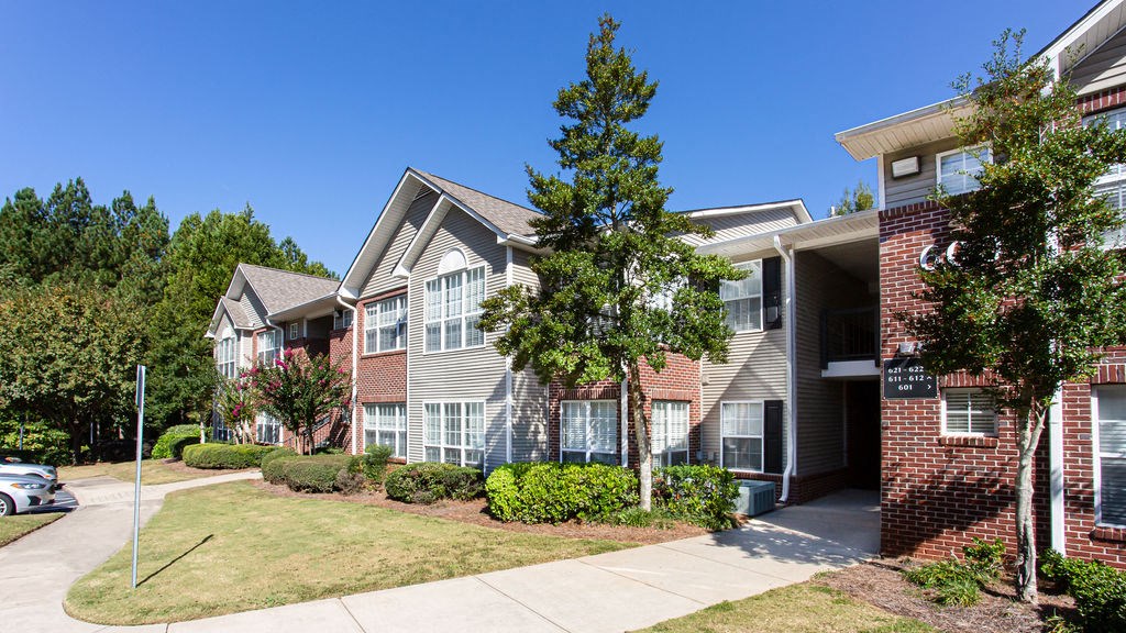 an exterior view of an apartment building with trees in front of it at Indigo Apartments Gainesville, Gainesville, GA