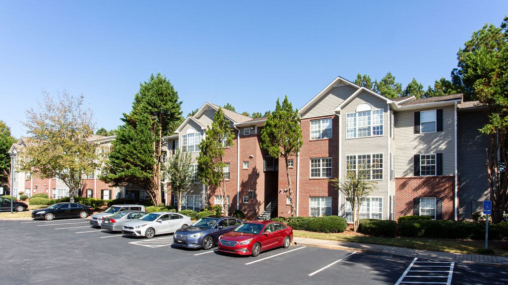 a parking lot with cars in front of an apartment building at Emery Village, Georgia, 30504