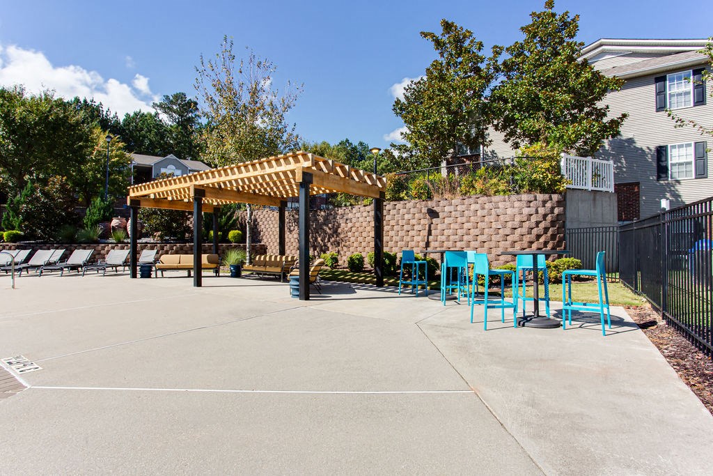 a patio with tables and chairs and a pergola at Indigo Apartments Gainesville, Gainesville, GA