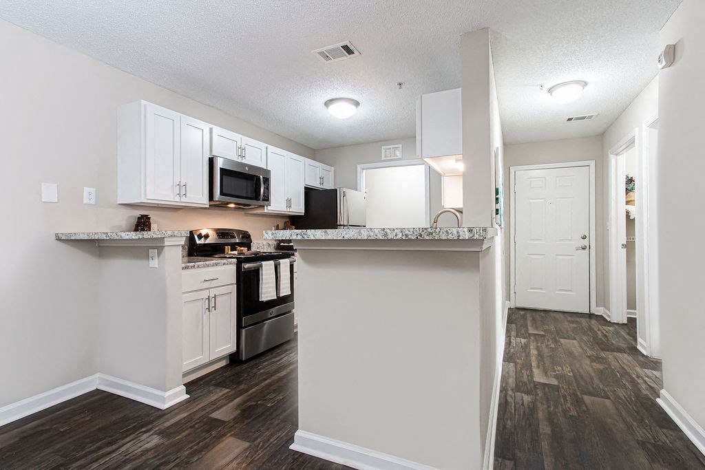 a kitchen with white cabinets and a counter top at Indigo Apartments Gainesville, Gainesville, GA 30504