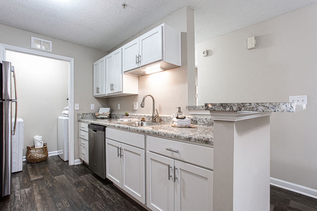 a kitchen with white cabinets and granite counter tops at Indigo Apartments Gainesville, Gainesville Georgia    at Indigo Apartments Gainesville, Gainesville