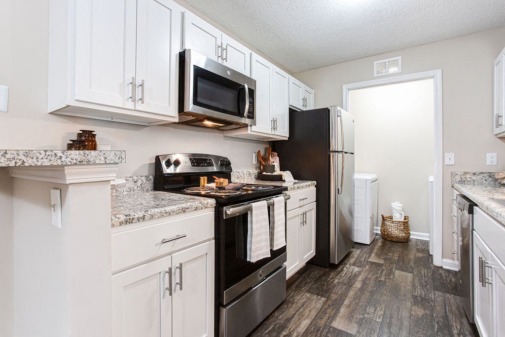a kitchen with stainless steel appliances and white cabinets at Indigo Apartments Gainesville, Gainesville, 30504