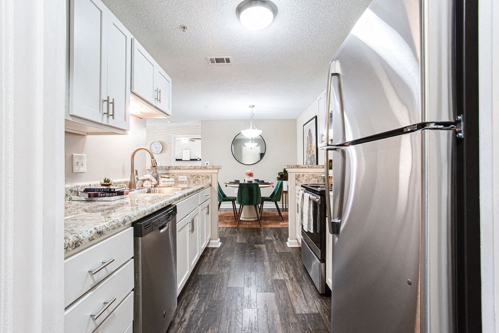 a large kitchen with white cabinets and stainless steel appliances at Indigo Apartments Gainesville, Georgia