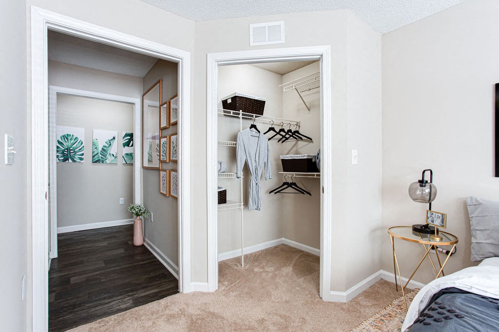 a bedroom with a closet and a bed and a mirror at Indigo Apartments Gainesville, Gainesville Georgia
