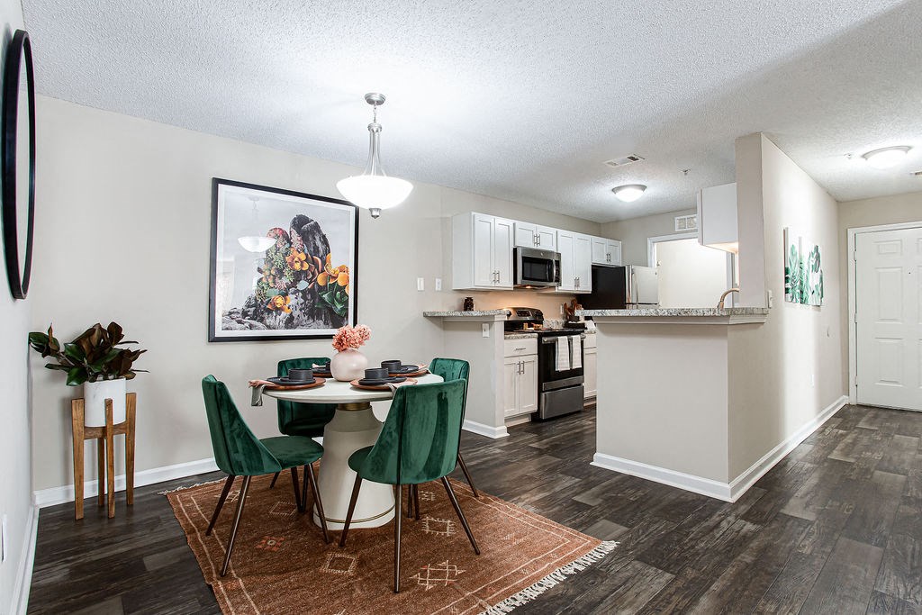 an open kitchen and dining area with a table and chairs at Indigo Apartments Gainesville, Gainesville, GA