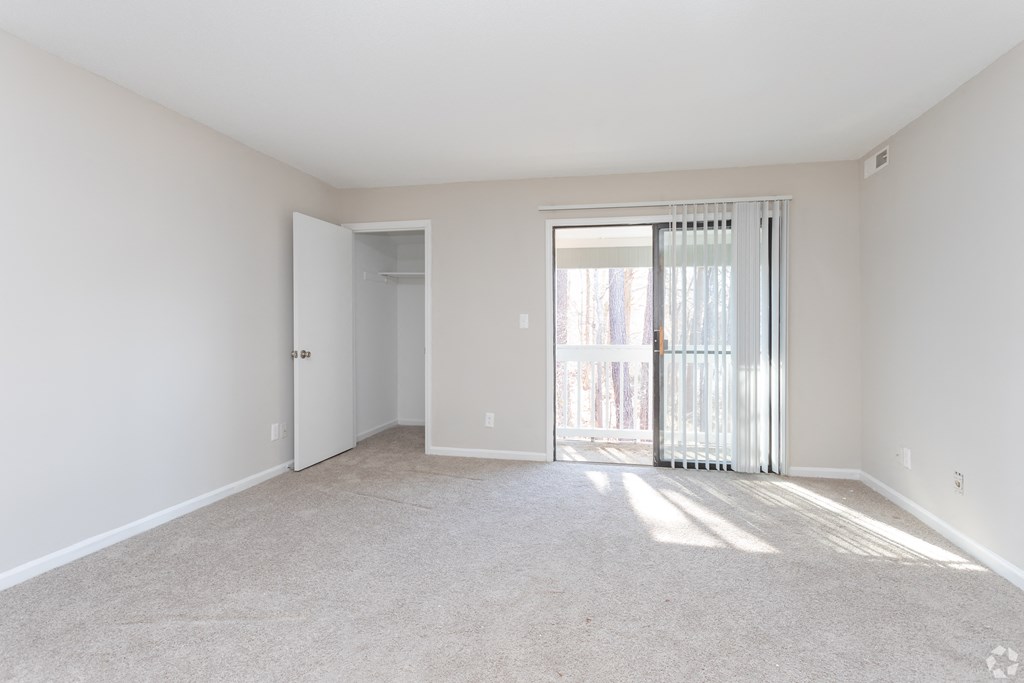 a bedroom with a sliding glass door leading to a balcony at Tiffany Square, Rocky Mount, NC