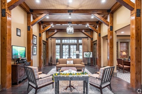 a large living room with wooden beams and a table