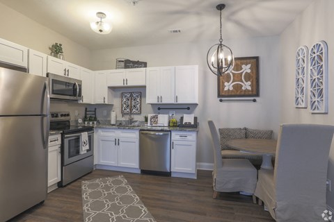 a kitchen and dining room with stainless steel appliances and a table