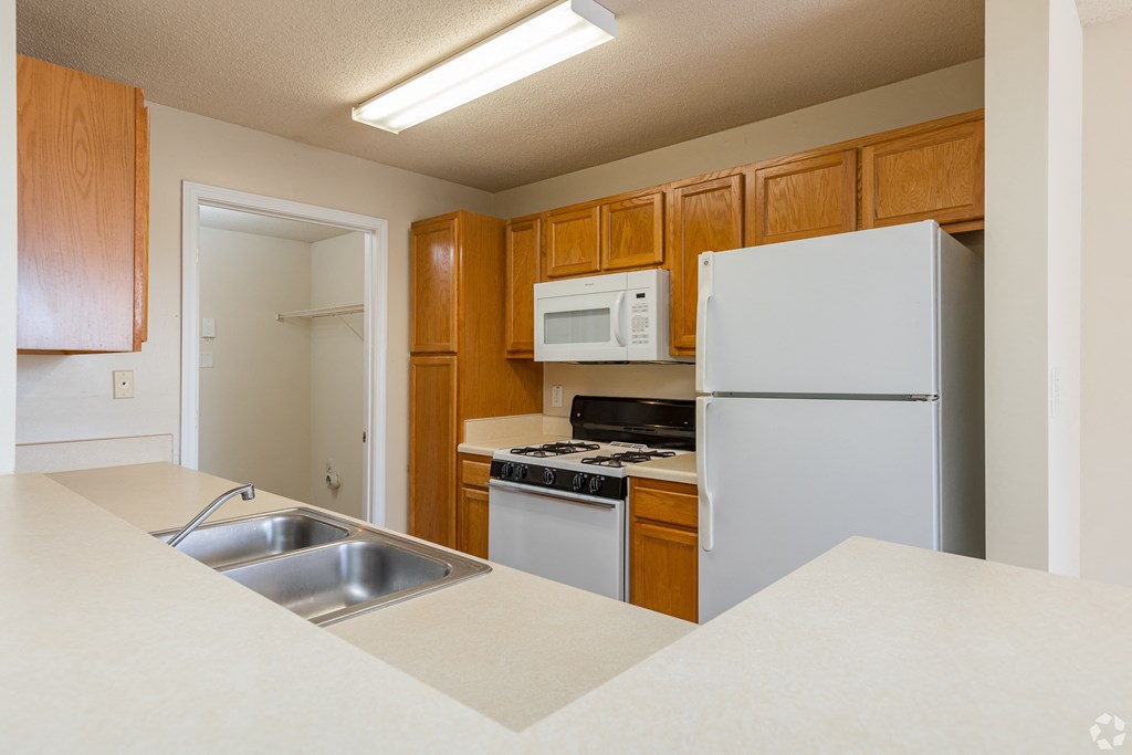 a kitchen with white appliances and wooden cabinets