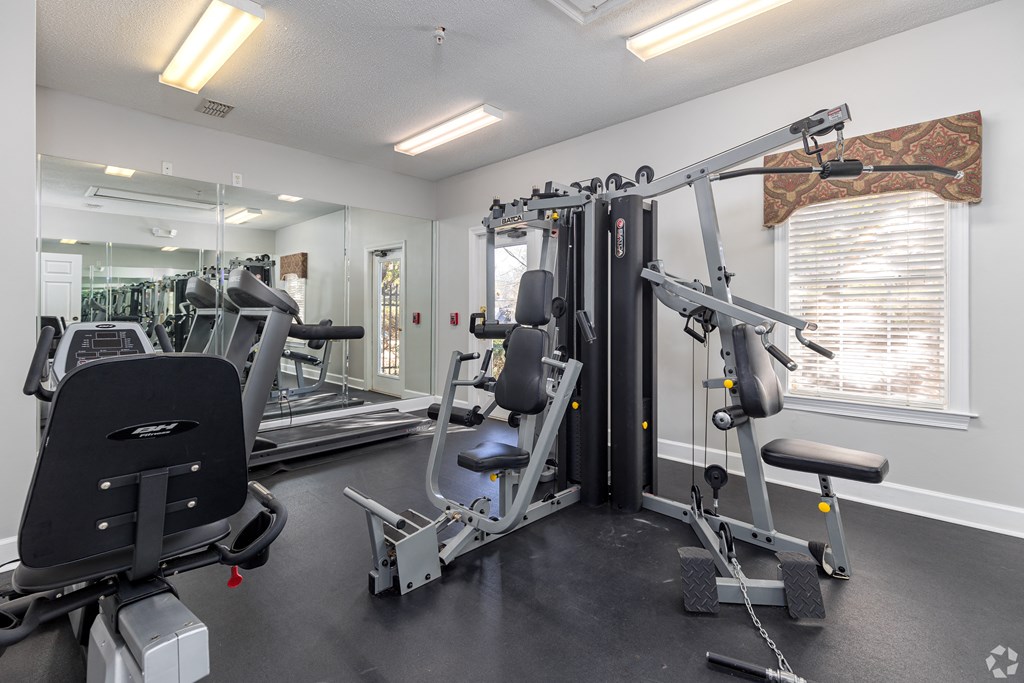 a gym with exercise equipment and mirrors on the wall