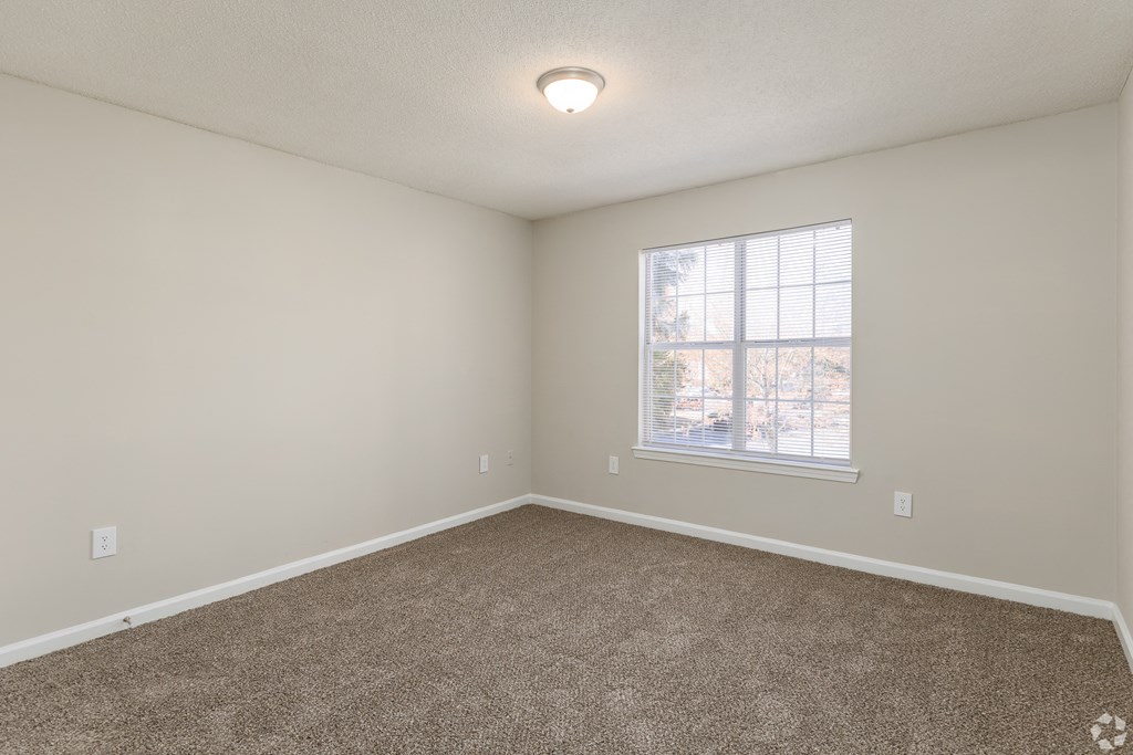 an empty room with carpet and a window