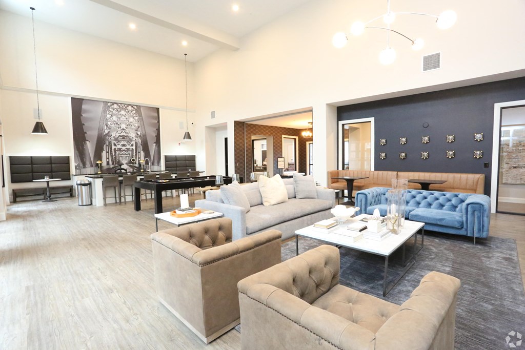 a living room with couches and chairs and a dining room with a table at Century Baxter Avenue, Louisville, KY