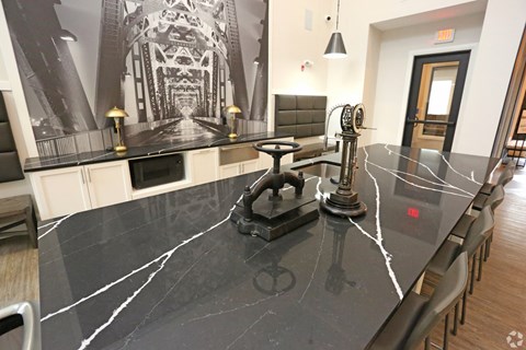 a large kitchen with a black counter top and a dining room table with chairs at Century Baxter Avenue, Louisville, KY 40204