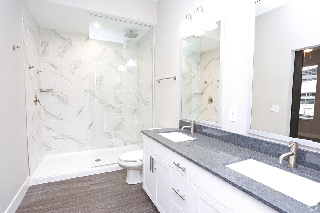 a bathroom with a shower and a sink and a mirror at Century Baxter Avenue, Louisville, KY 40204