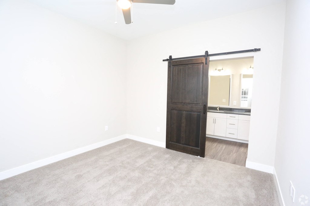 an empty living room with a wooden sliding door to a bathroom at Century Baxter Avenue, Kentucky, 40204
