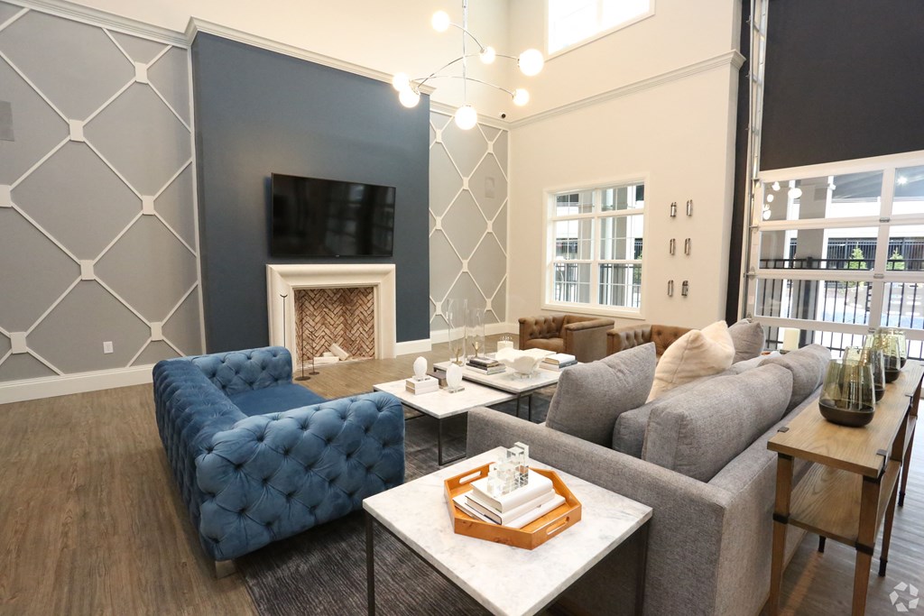 a living room with blue couches and a fireplace at Century Baxter Avenue, Louisville